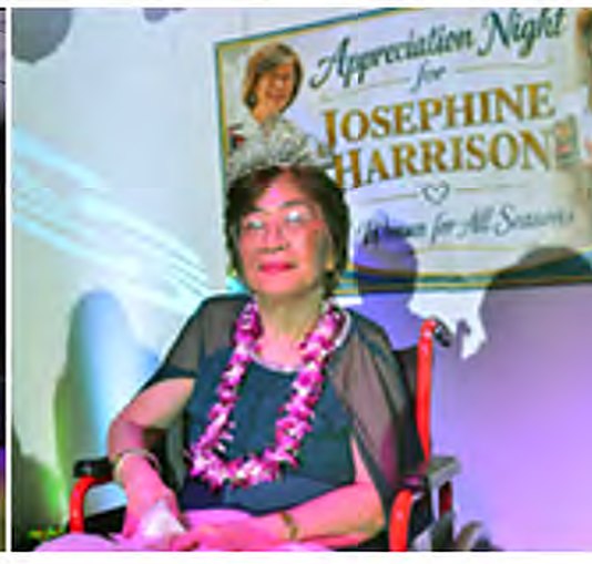 Josephine "Josie" Harrison in a tiara and lei beneath her "A Woman for All Seasons" appreciation banner