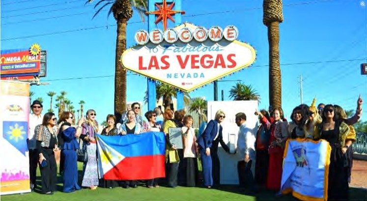 NaFFAA Nevada members and supporters hold a Philippine flag in front of the Welcome to Fabulous Las Vegas sign